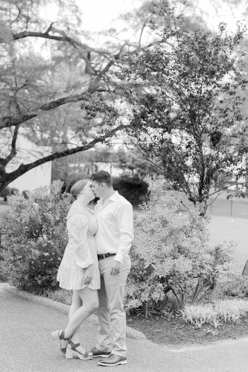 engaged couple kissing in black and white photo during engagement session